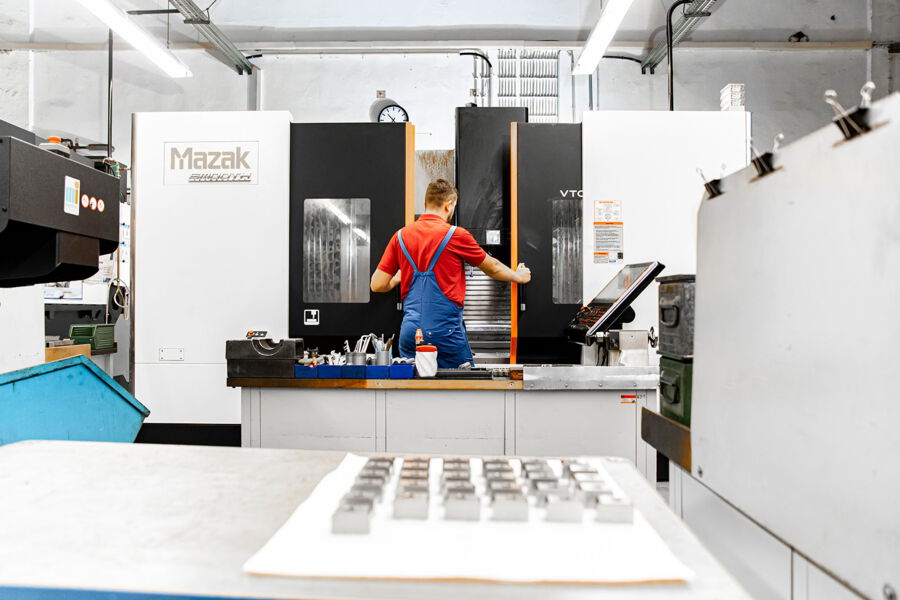 OPTIMA-Mitarbeiter bedient CNC-Fräsmaschine zur Fertigung von CNC-Frästeilen